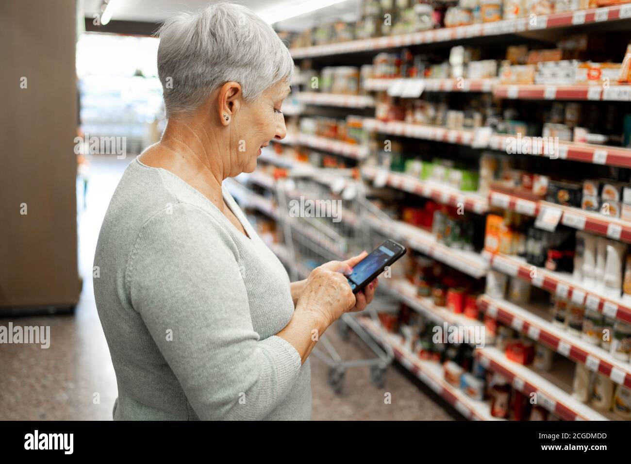 Caucasian elderly woman with white hair  shopping in supermarket Stock Photo