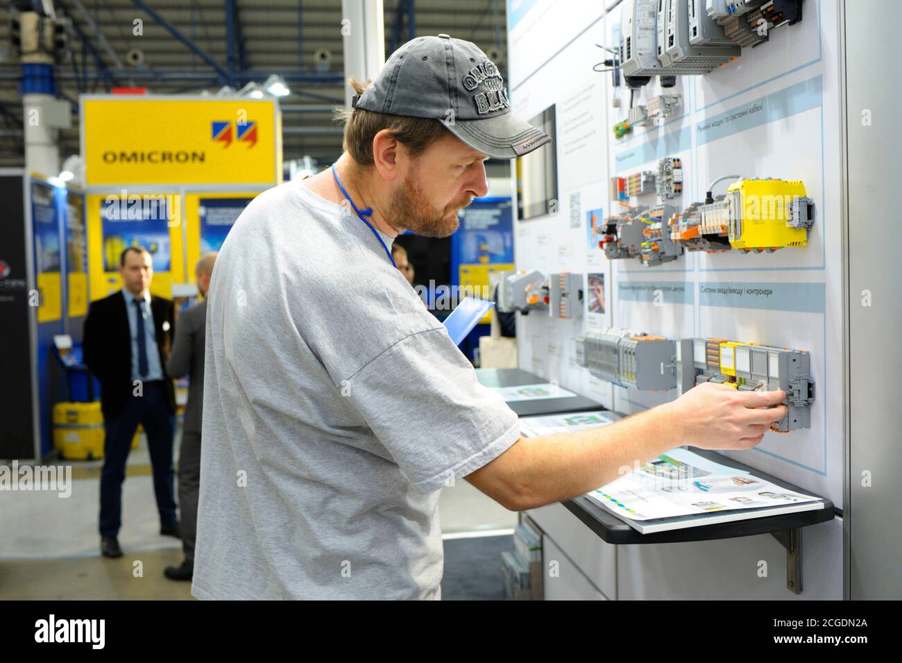 Visitor touching the block of the automatic control system of the power supply presented on the stand. Exhibition Industrial Ukraine-2019. November 6, Stock Photo