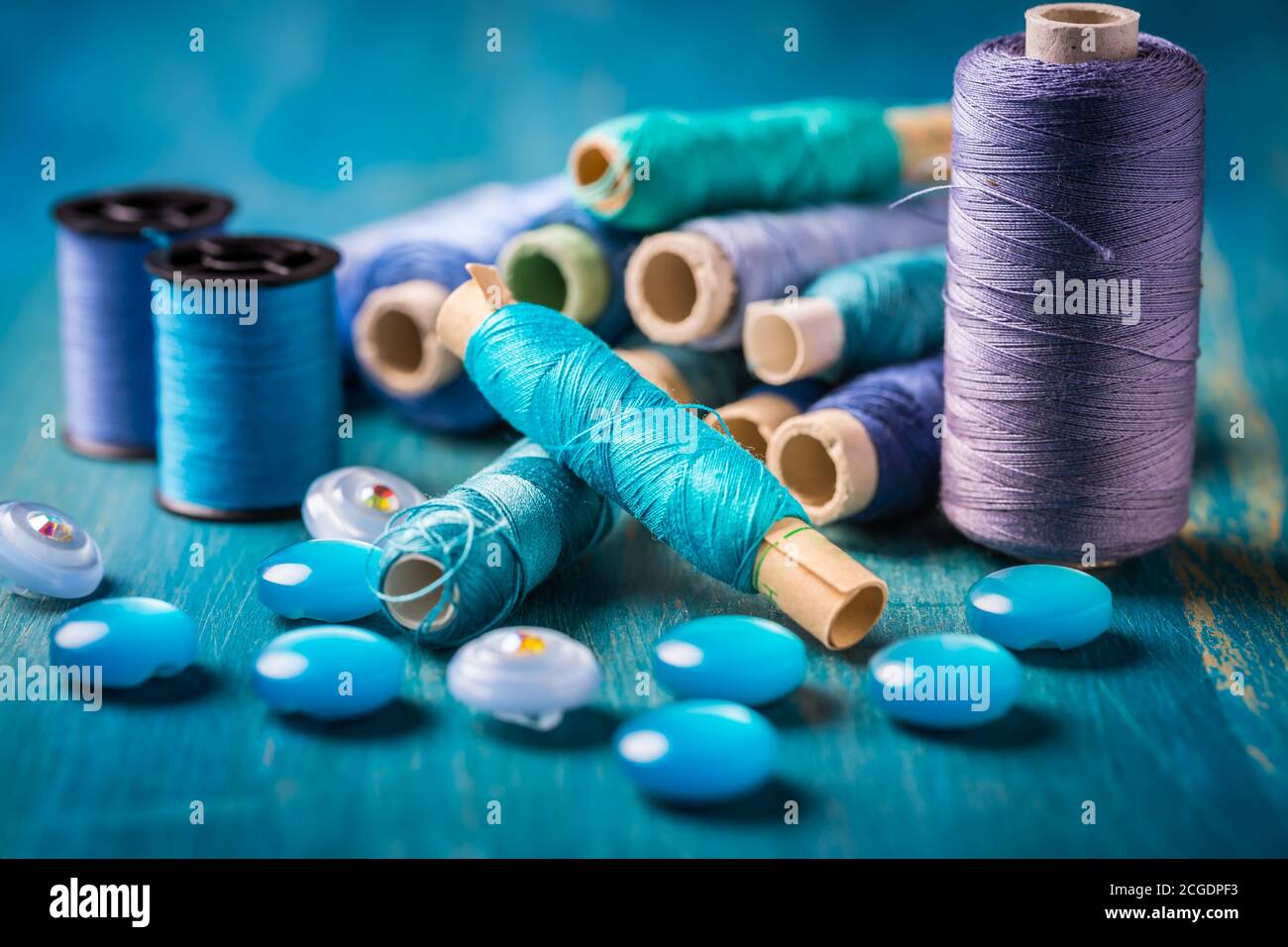 Sewing threads and sewing buttons, spools in blue tone. Needlework and tailoring concept Stock