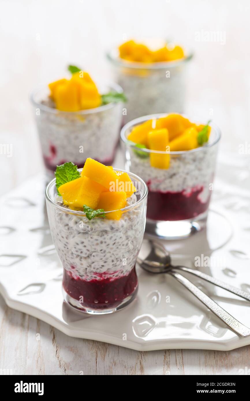 Healthy chia seed pudding with yogurt, raspberry mousse and fresh mango