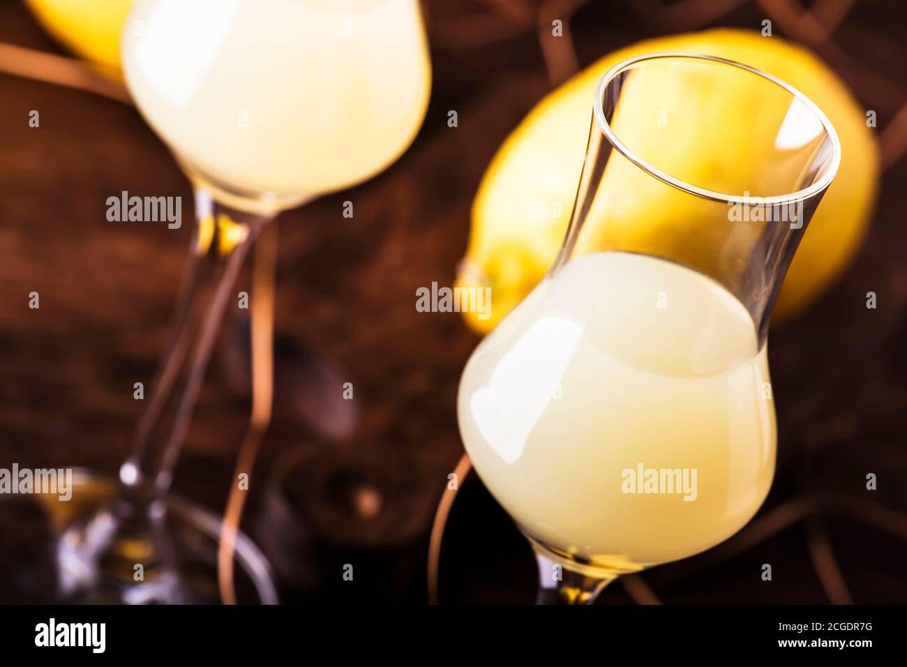 Limoncello, sweet Italian lemon liqueur, traditional strong alcoholic drink. Still life in vintage style, selective focus Stock Photo