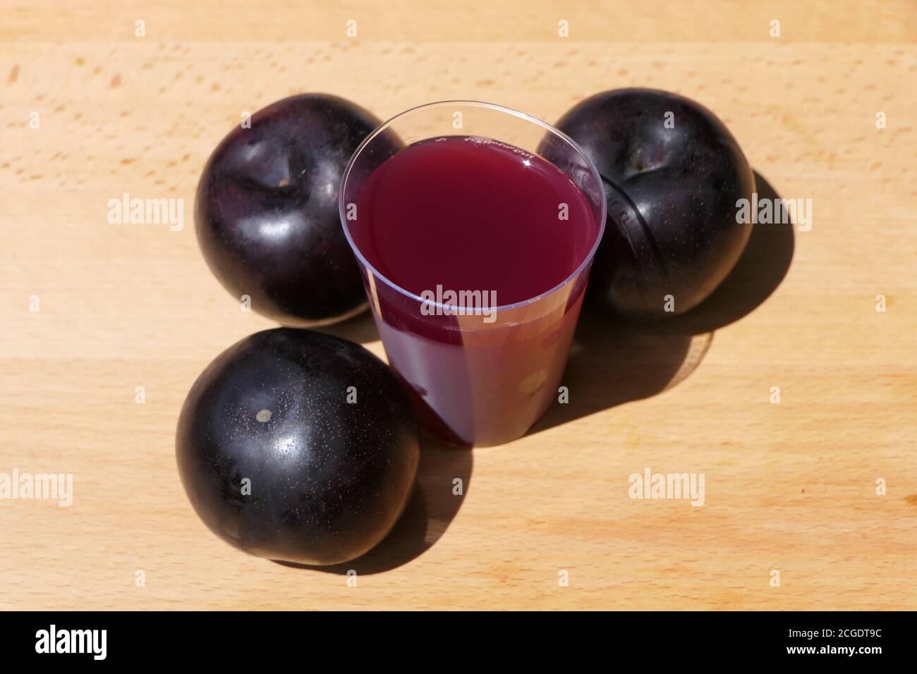 Plums and freshly squeezed plum juice in a cup Stock Photo