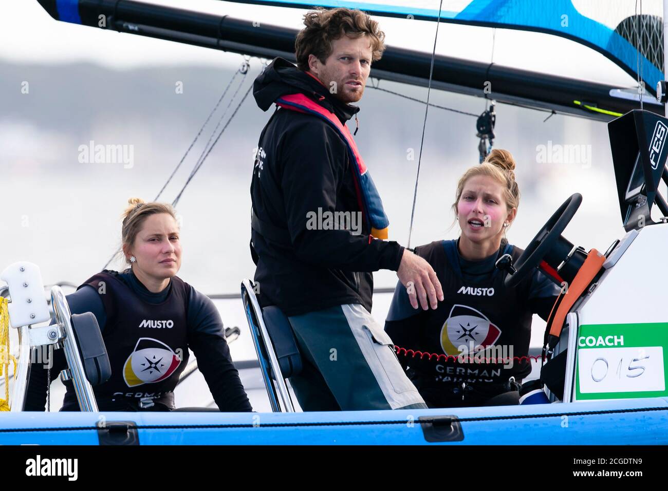 Kiel, Germany. 10th Sep, 2020. Berlin 49erFX sailors Vicky Jurczok (r) and Anika Lorenz look into the camera after a race at the 126th Kieler Woche. in the middle is national coach Dave Evans. The Kieler Woche is considered the world's largest sailing event and ends on 13.09.2020. Credit: Frank Molter/dpa/Alamy Live News Stock Photo