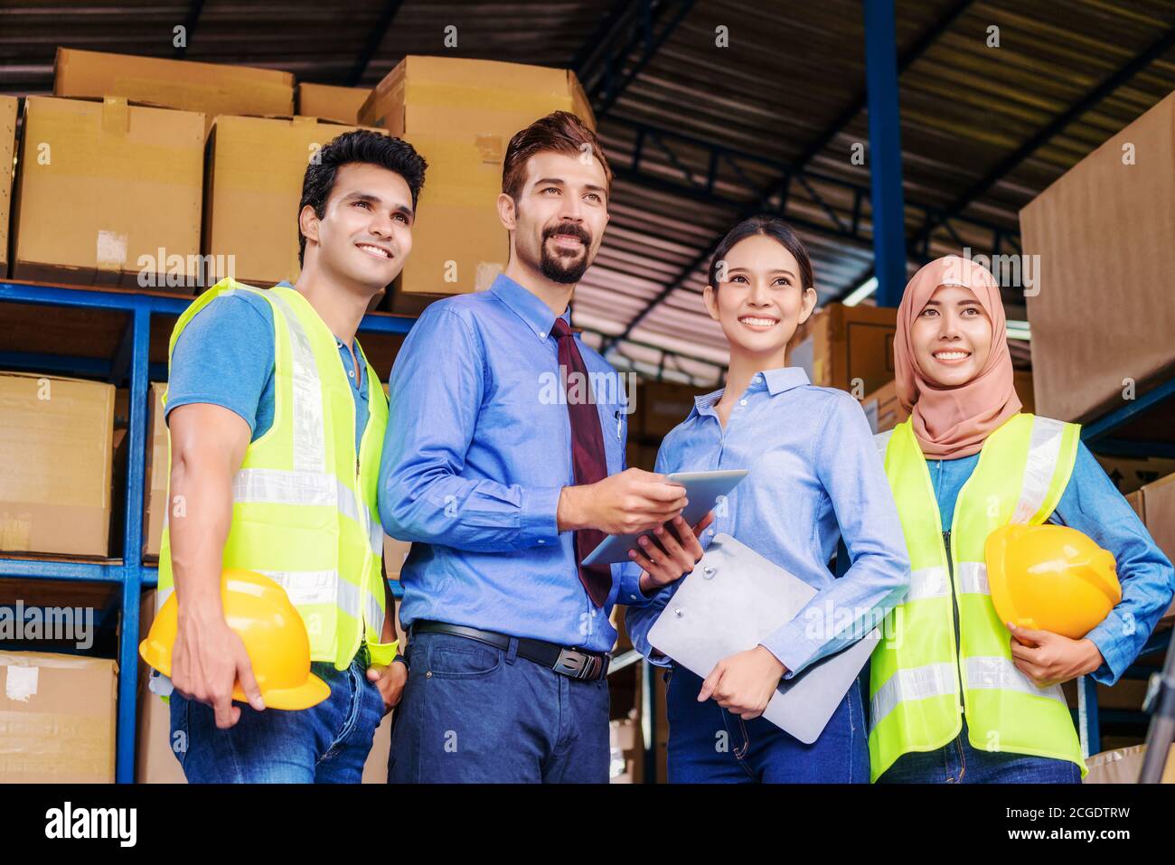 Group of Diversity warehouse worker standing and Proud of the team for vision and target of manager in local warehouse, muslim, indian, white caucasia Stock Photo