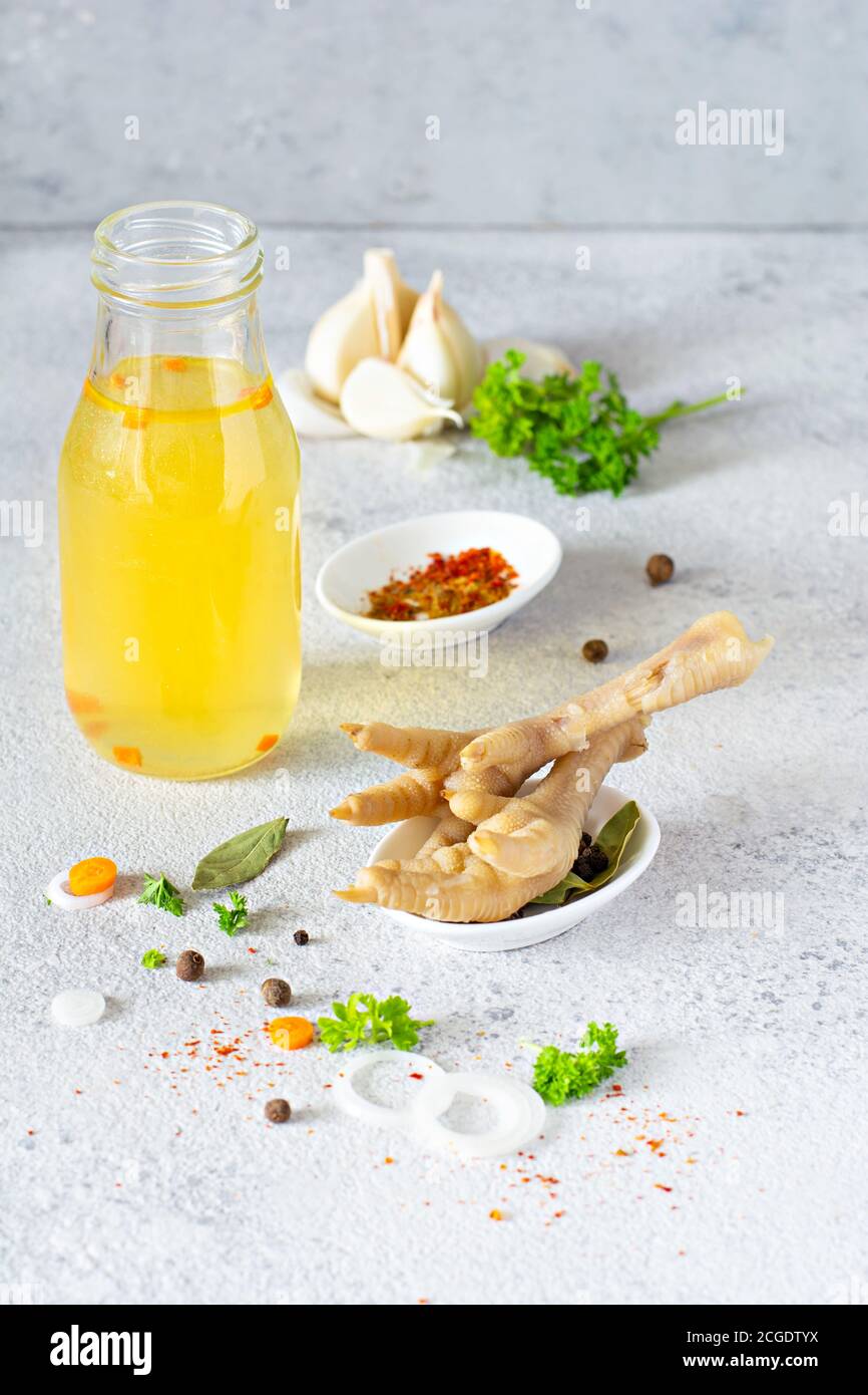 Homemade chicken (bone) broth/bouillon with vegetables, spices and herbs in a bowl (cup) on a light background. Natural collagen of animal origin. Liq Stock Photo