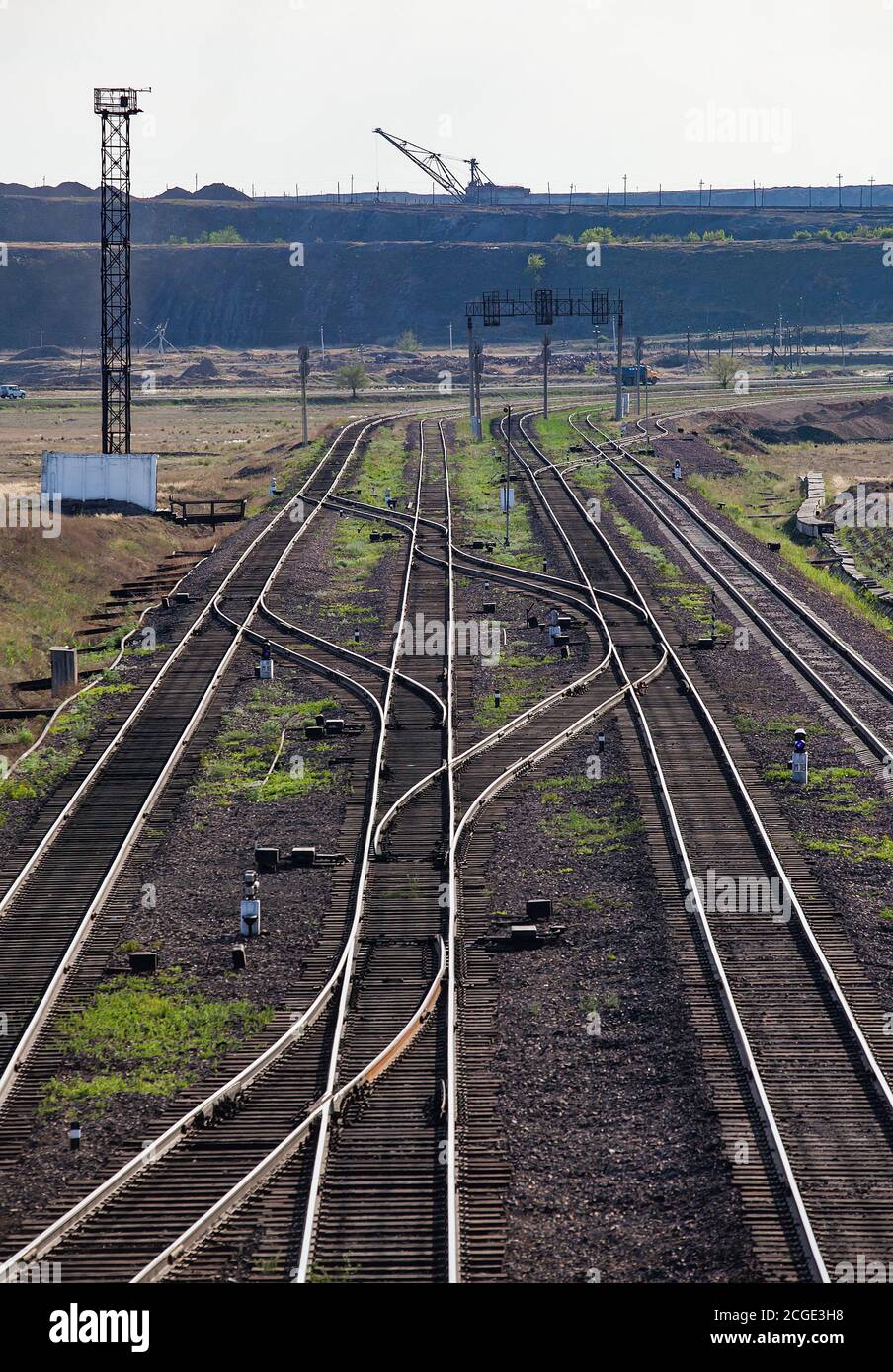 Ekibastuz, Kazakhstan. Railway station 'Bogatyr' near coal quarry. Rails tracks and dragline excavator on background. Stock Photo
