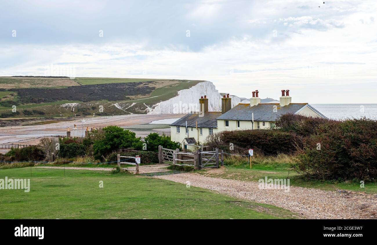 The famous coastguard cottages on the cliffs overlooking Cuckmere Haven at Seaford Head Nature Reserve . The cottages are in danger because of erosion Stock Photo