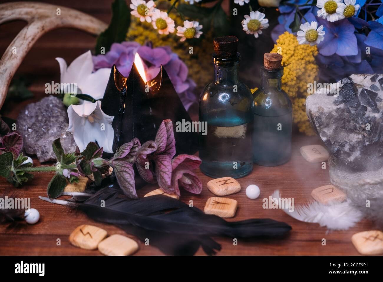 Magic potion bottle. Witchcraft halloween concept with potions, herbs and occult equipment. Magical still life with copy space on a dark background. Stock Photo