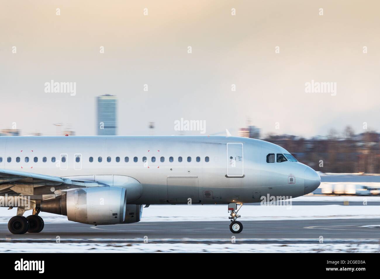 Silver passenger airplane taxiing on runway to take off in winter day, side view. Aviation, transportation, travel Stock Photo