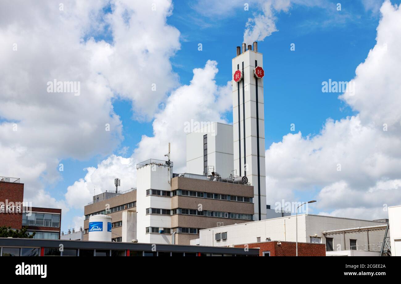 Office buildings and chimney of the Jacobs Douwe Egberts coffee roasting plant under a blue sky with clouds. Utrecht, The Netherlands. Stock Photo