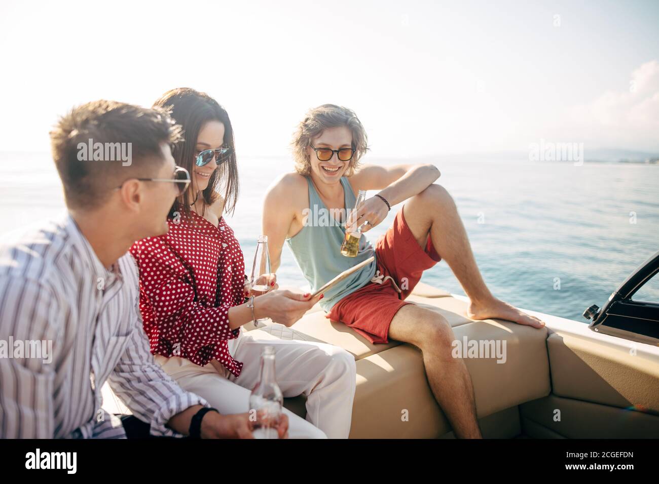 People on yacht drinking beers while talking Group of friends having