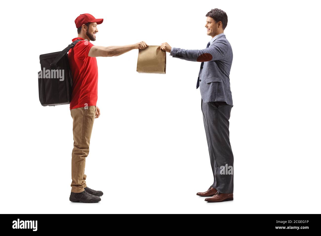 Full length profile shot of a guy delivering takeaway food bag to a man isolated on white background Stock Photo