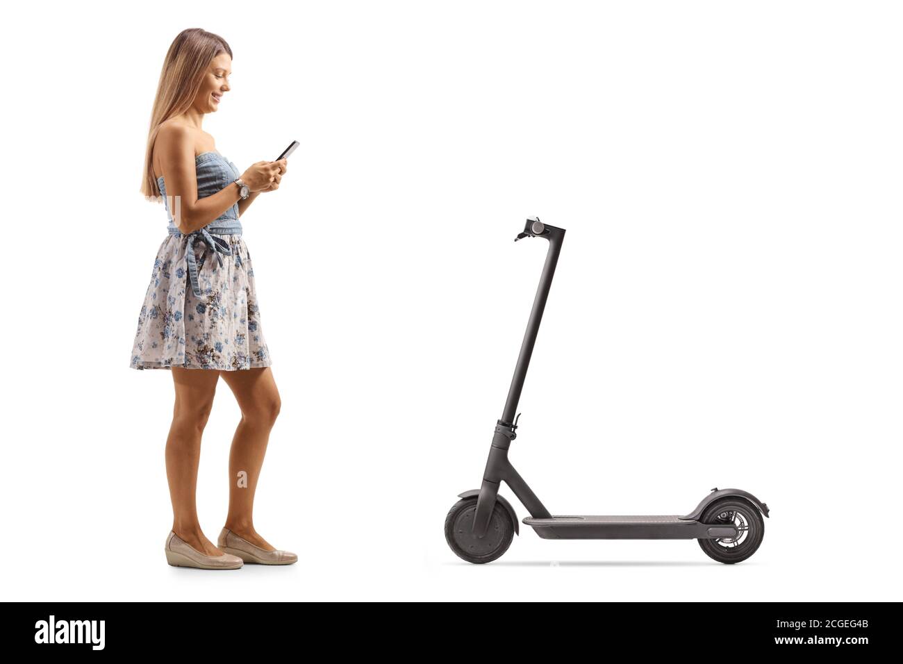 Full length shot of a young female renting an electric scooter with a mobile phone application isolated on white background Stock Photo