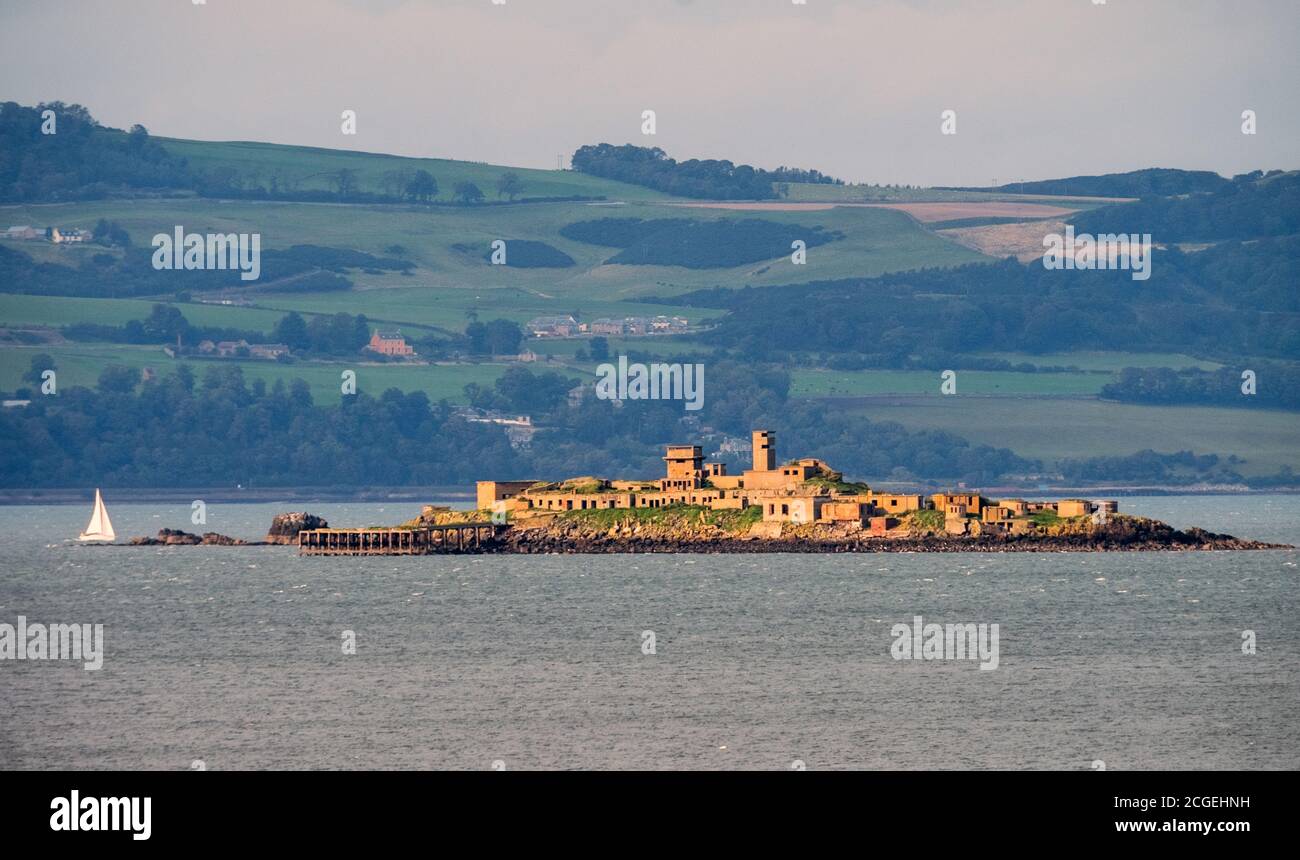A sailing boat passes Inchmickery Island in the Firth of Forth, Scotland. Stock Photo