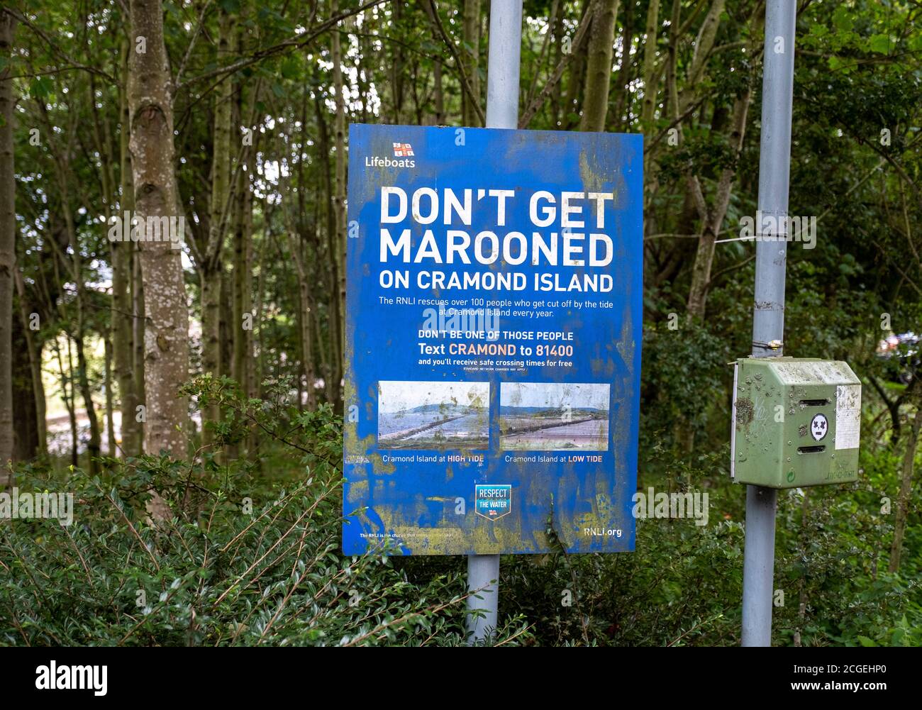 Sign at Cramond village car park Edinburgh, warning of the danger of getting marooned on Cramond Island in the Firth of Forth. Stock Photo