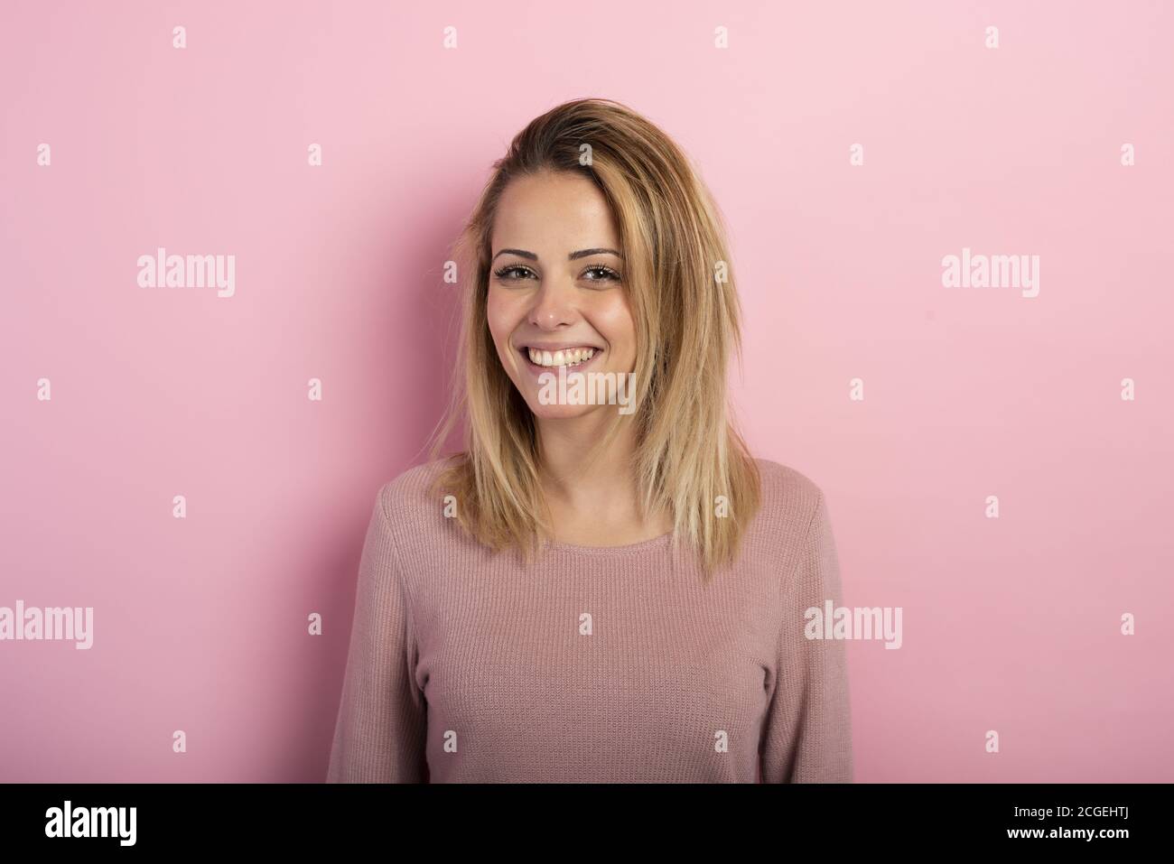 Happy and positive blonde girl against a pink background Stock Photo