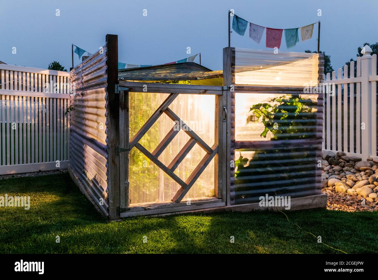 Residential vegetable garden covered with temporary tarp; bright lamps used to prevent an early season freeze. Stock Photo