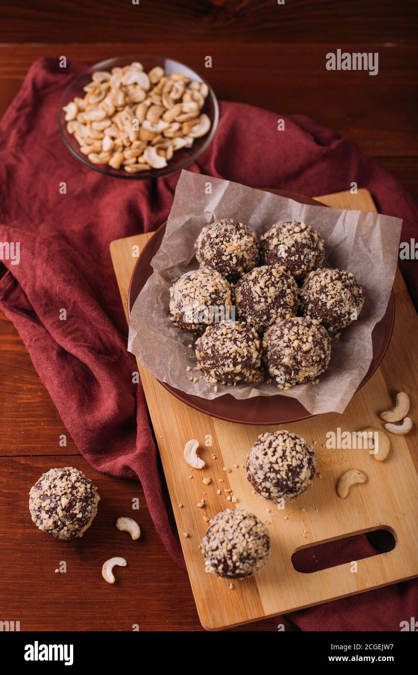 Cocoa balls, chocolate truffles cakes on board on wooden background