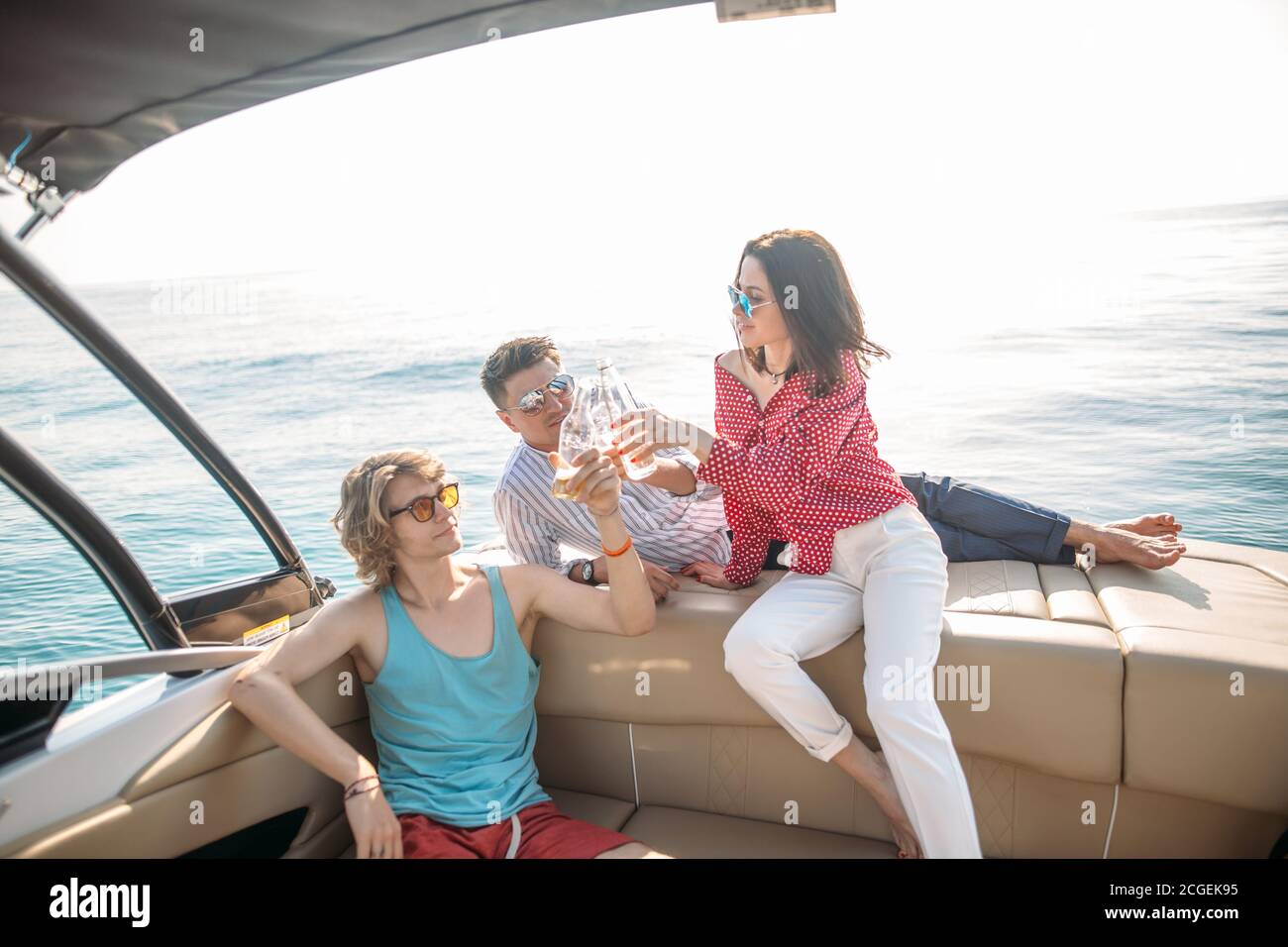 friends dancing and drinking beers at boat people having fun