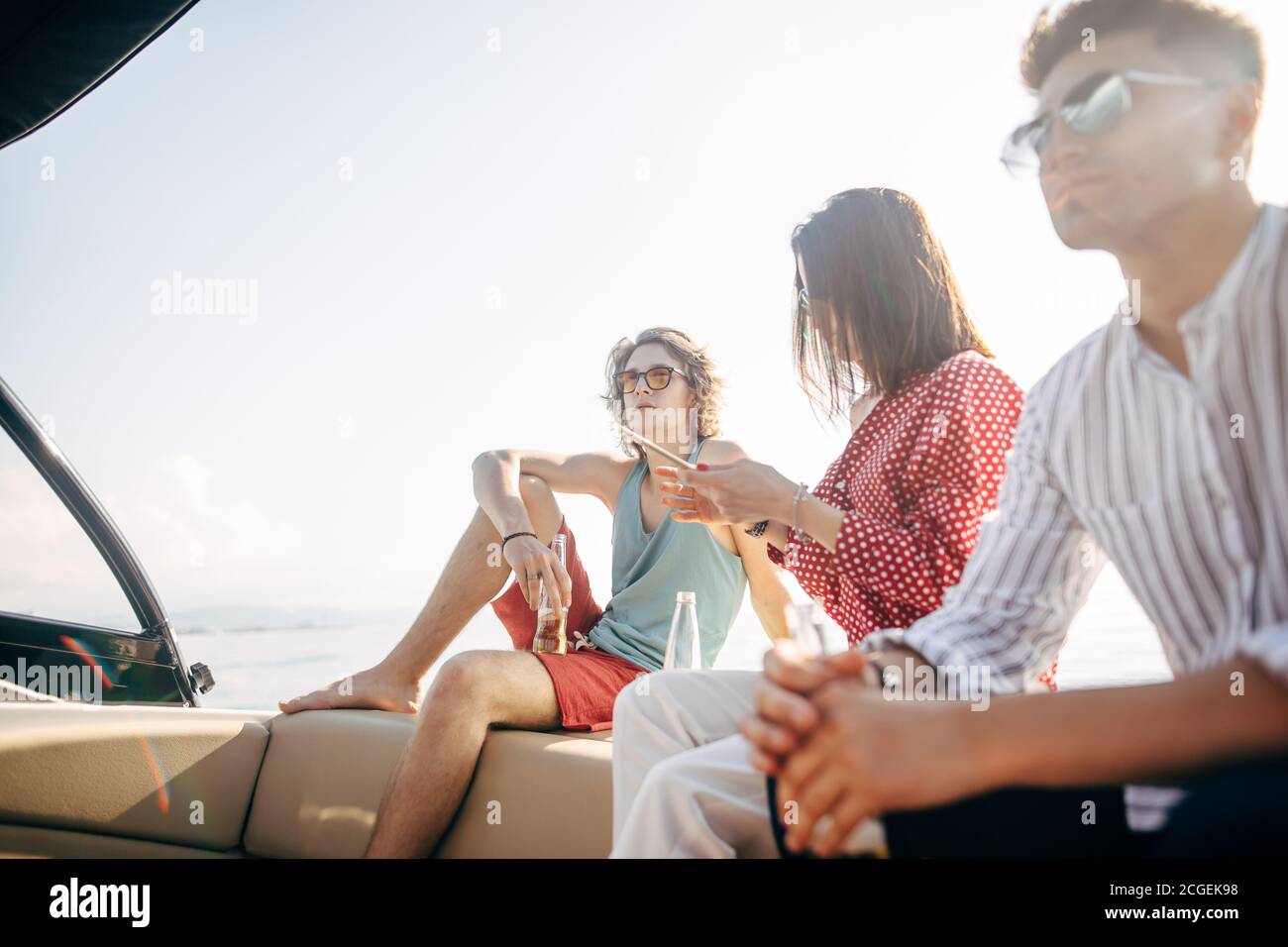 friends dancing and drinking beers at boat people having fun