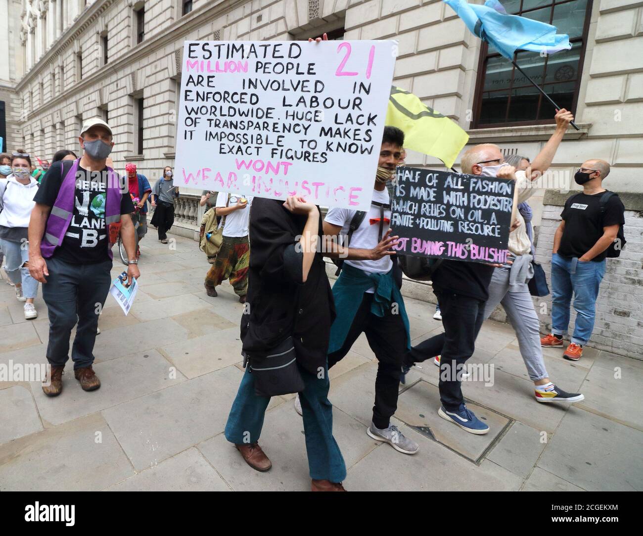 Protesters holding placards as they march near Westminster during the  Extinction Rebellion demonstration.Extinction Rebellion demonstrators march  to Westminster as part of their Redress the Injustice day of protest,  opposing the fashion industry's