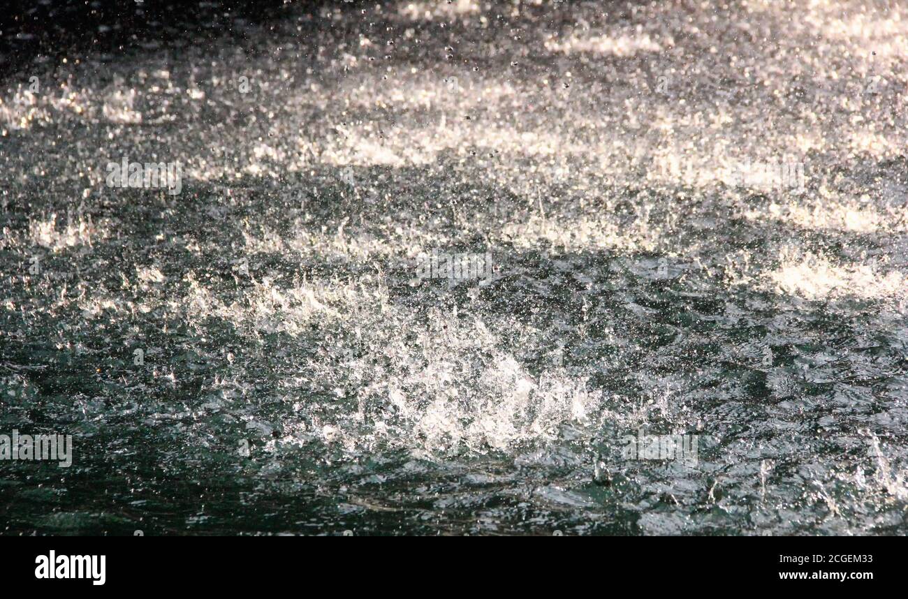 Water drops on the river surface, flowing from a waterfall. Stock Photo