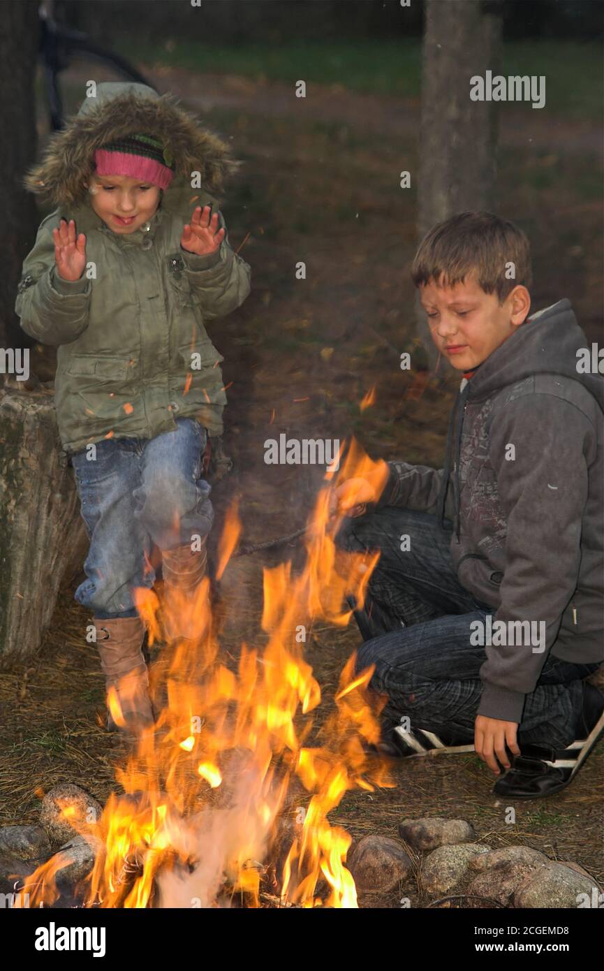 Poland, Polen, Polska; Boys playing by the fire, bonfire. Jungen spielen am Feuer. Niños jugando junto al fuego. Chłopcy bawią się przy ognisku. 男孩玩火。 Stock Photo