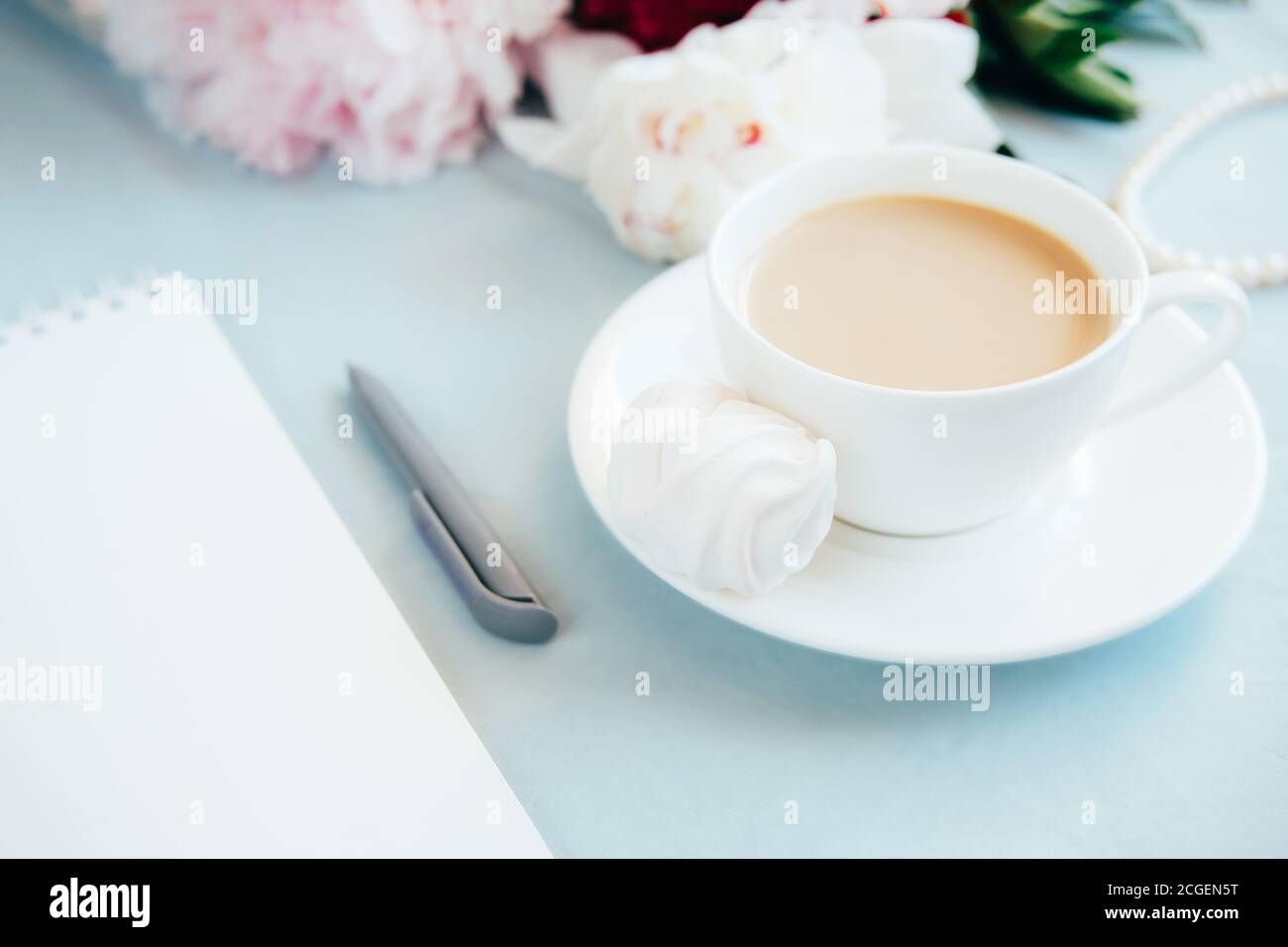 Blank notebook, pen and cup of coffee on the table. Stock Photo