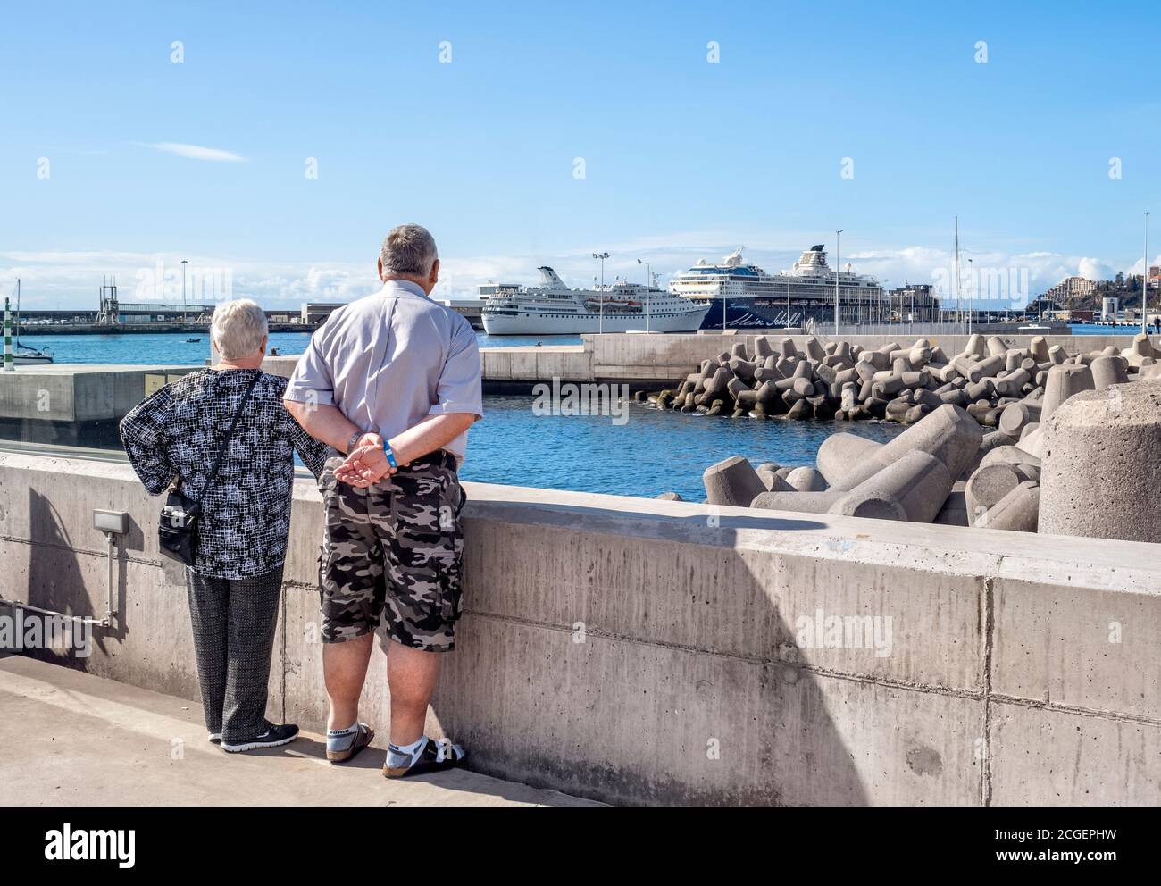 A couple watching Cruise Ships in Funchal Harbour, Madeira. Stock Photo