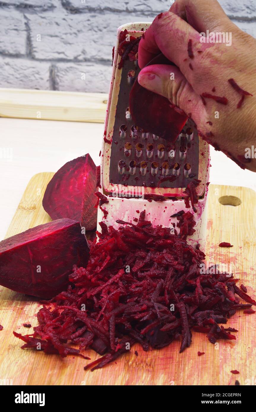 grate beetroot on a grater, fresh beet grated Stock Photo