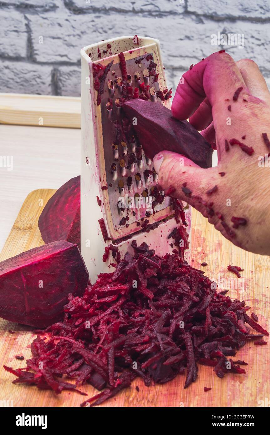 grate beetroot on a grater, fresh beet grated Stock Photo