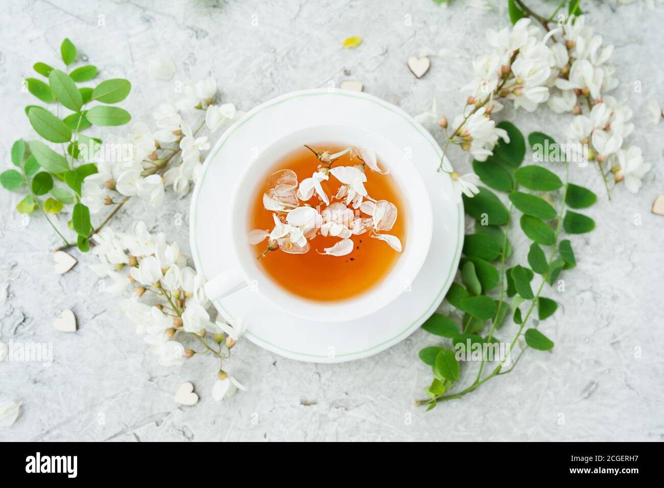 white acacia flowers tea in a white porcelain Cup on a white cement