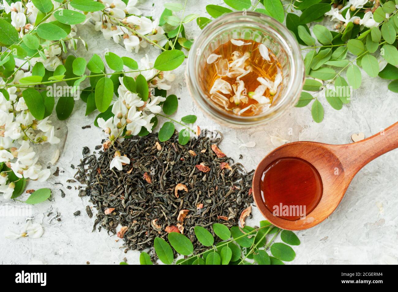 dried tea leaves with berries, acacia flowers broth in glassware cup