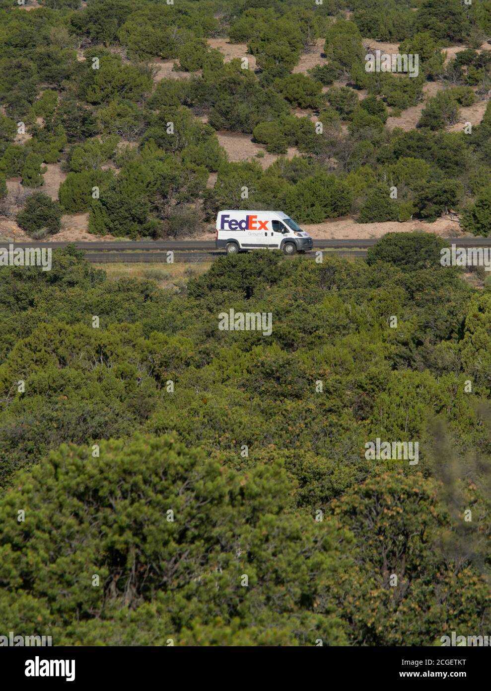 A Federal Express, or FedEx truck traveling along a rural road in the American Southwest. Stock Photo