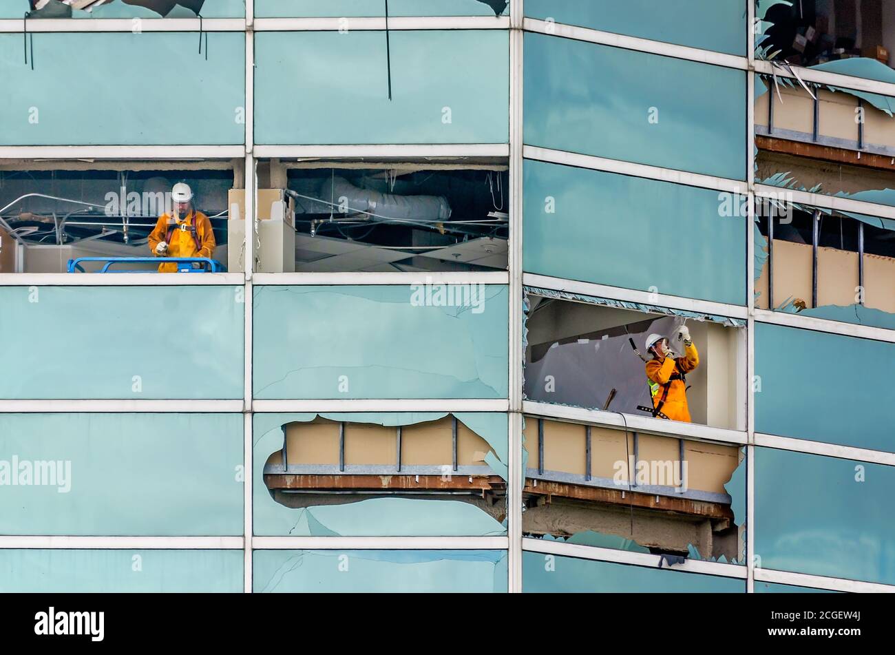 Workers remove the shattered glass from windows at the Capital One Tower after Hurricane Laura, Sept. 9, 2020, in Lake Charles, Louisiana. Stock Photo