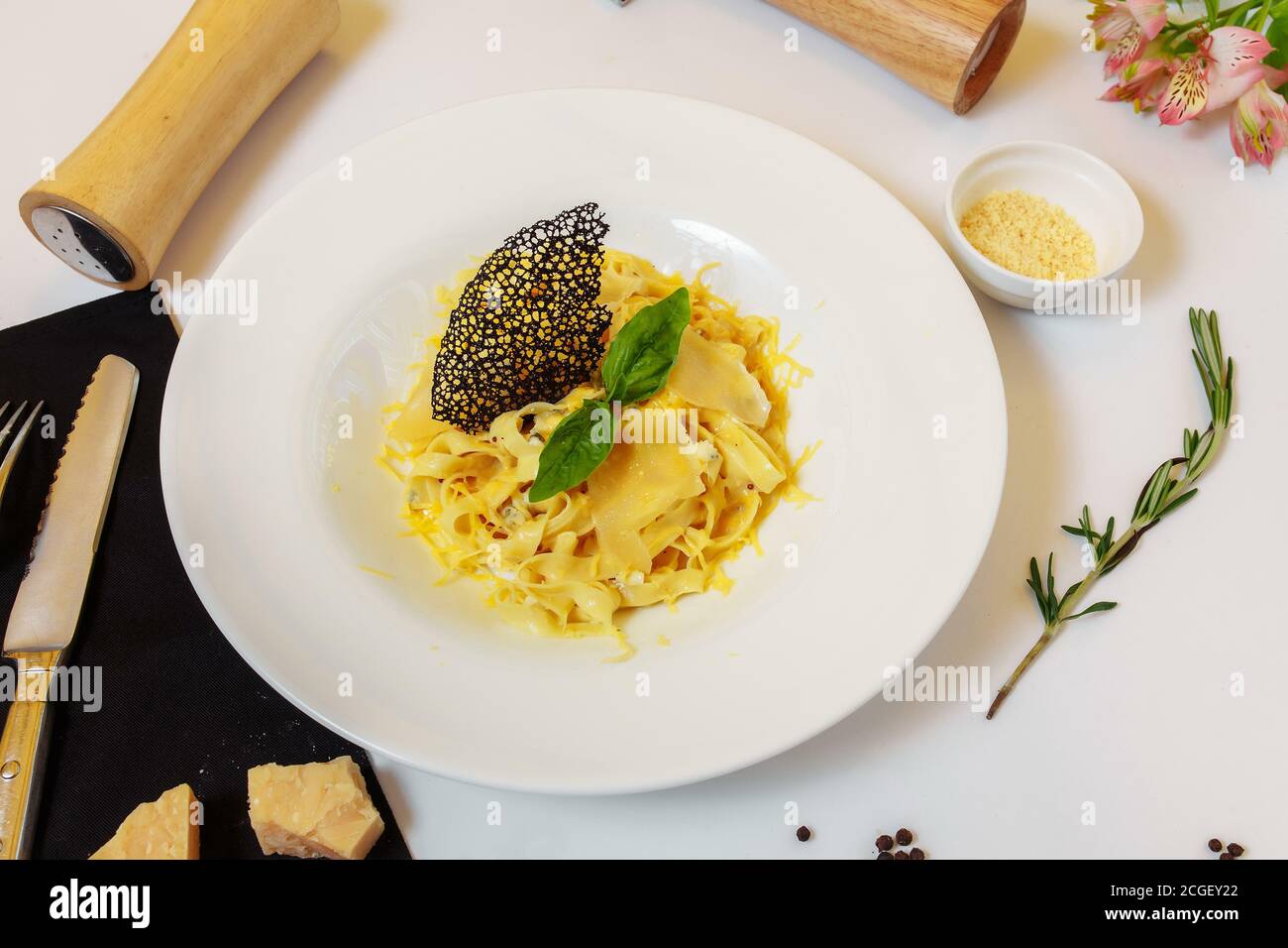 Pasta four cheeses. Homemade pasta, cream cheese sauce, Dor Blue, Cheddar, Parmesan, basil. Italian food. On a wooden background. Free space for text Stock Photo