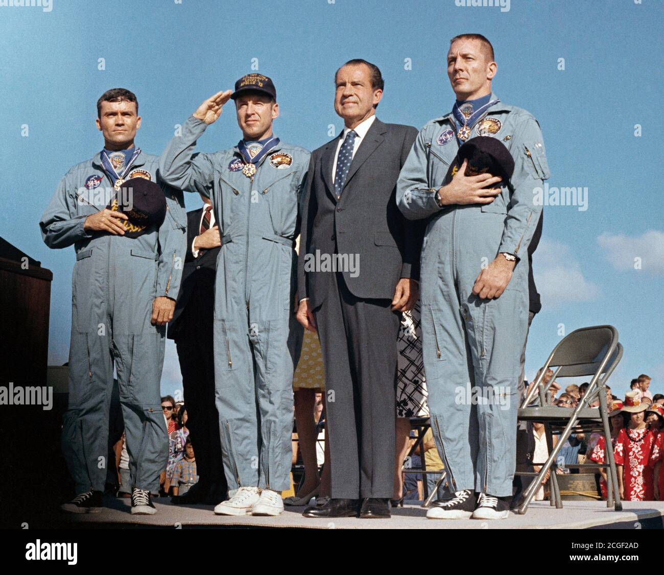 (18 April 1970) --- President Richard M. Nixon and the Apollo 13 crew members pay honor to the United States flag during the post-mission ceremonies at Hickam Air Force Base, Hawaii. Astronauts James A. Lovell Jr., (United States Navy Captain, salutes the flag) commander; John L. Swigert Jr., command module pilot (right); and Fred W. Haise Jr., lunar module pilot (left), were presented the Presidential Medal of Freedom by the Chief Executive. Stock Photo