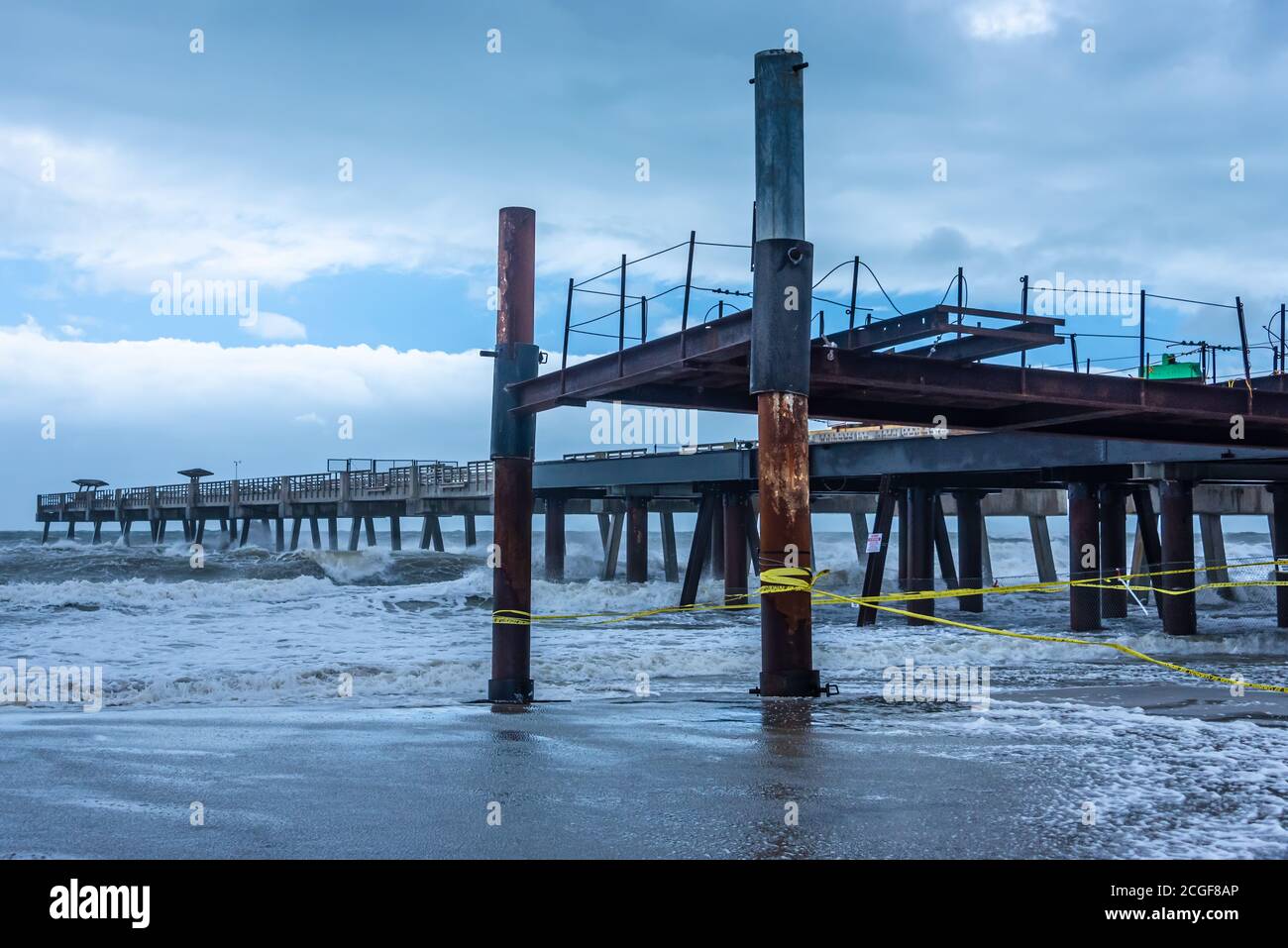 Hurricane-damaged pier reconstruction at Jacksonville Beach, Florida as heavy surf pounds the beach while Tropical Storm Isaias passes offshore. (USA) Stock Photo