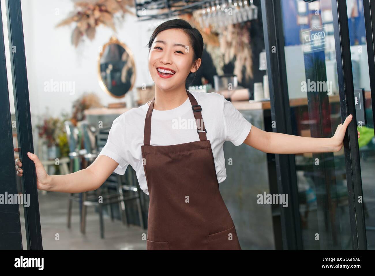 Standing at the door of the cafe waitress Stock Photo