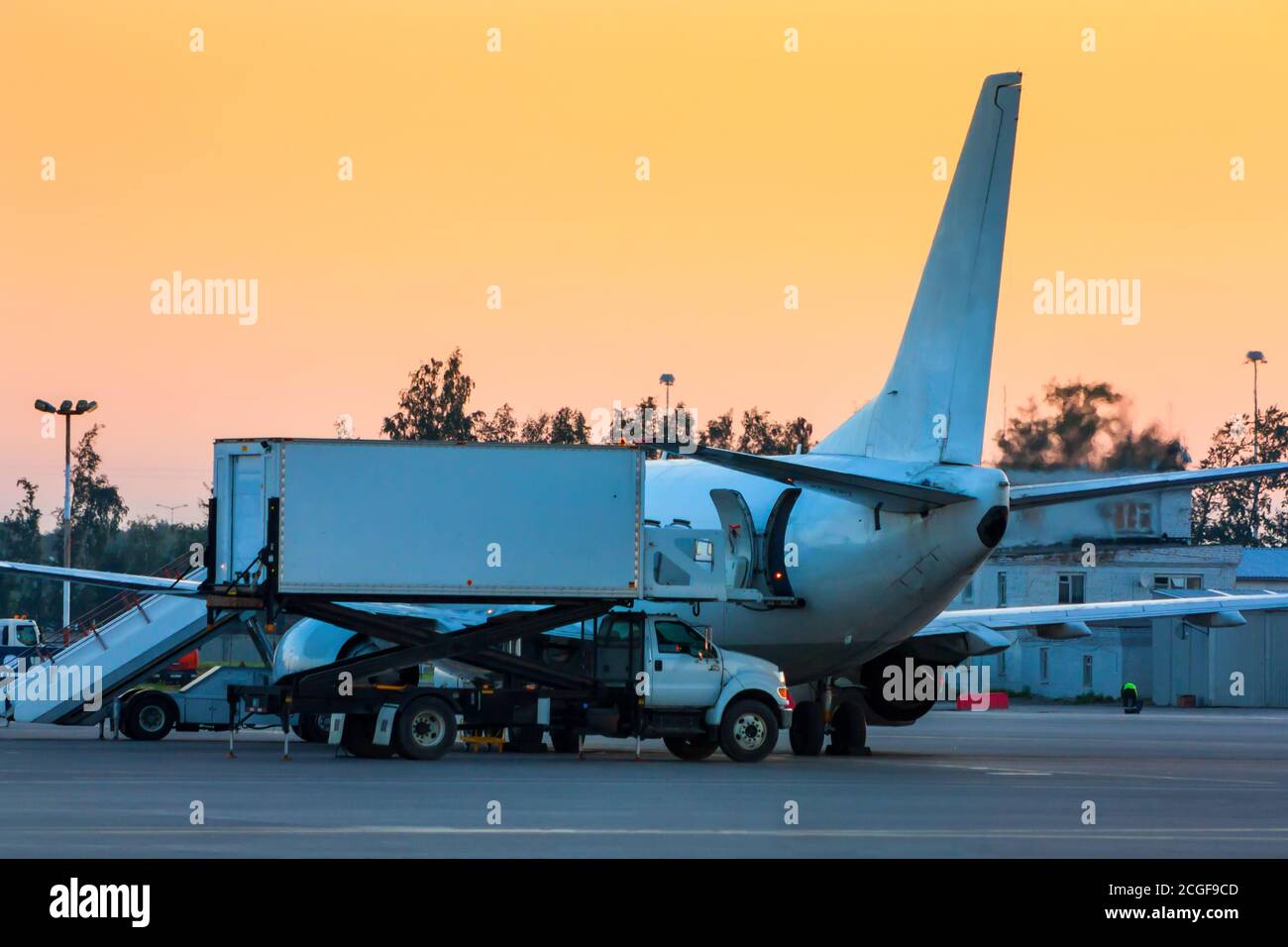 Loading food on a plane in the early morning Stock Photo - Alamy