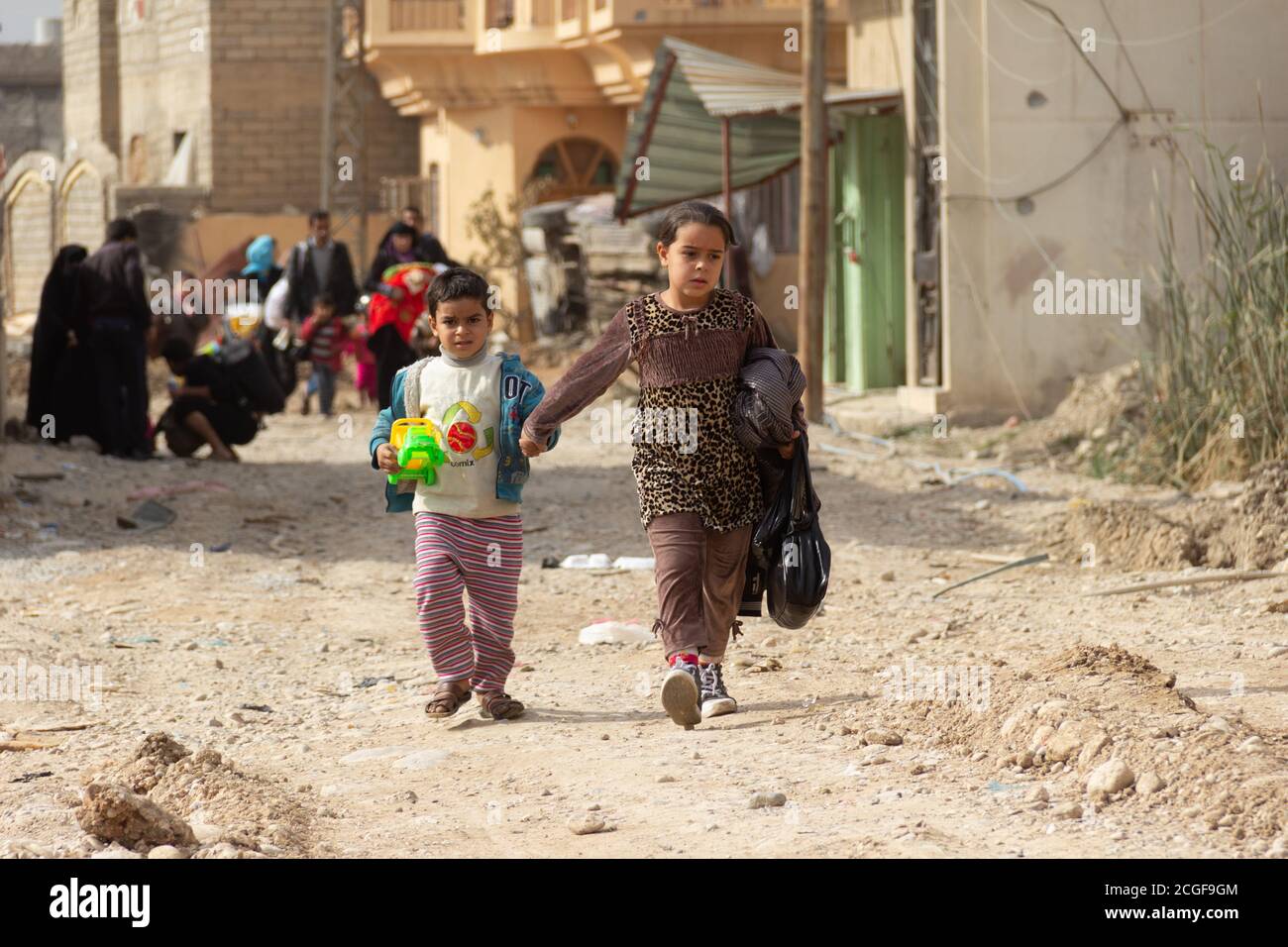 Two children flee from the war in Al Bakir district of East Mosul, Iraq. Stock Photo
