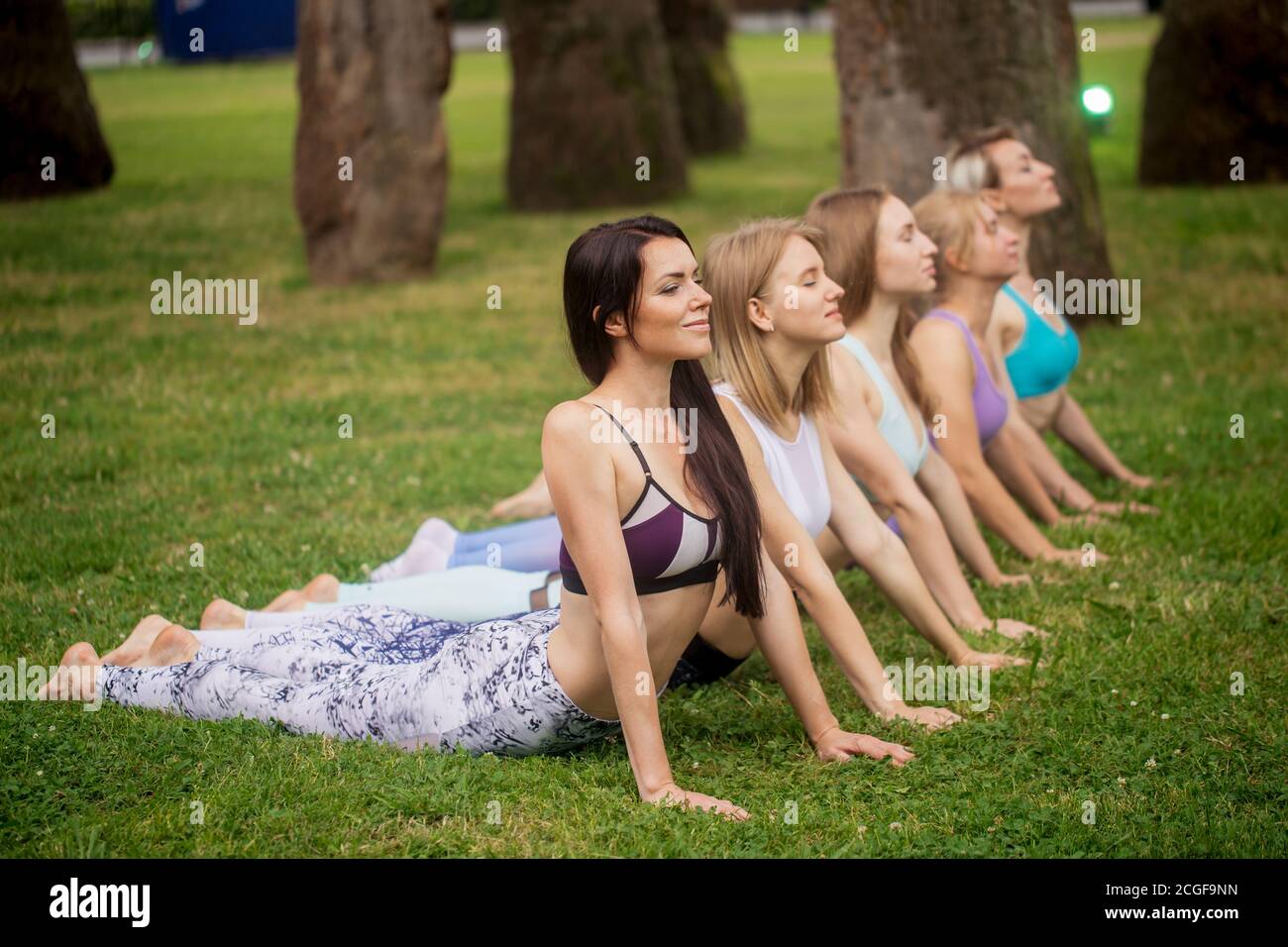 Free Photo  Vertical shot of smiling korean woman doing tree yoga asana  stretching on rubber mat in park exercis