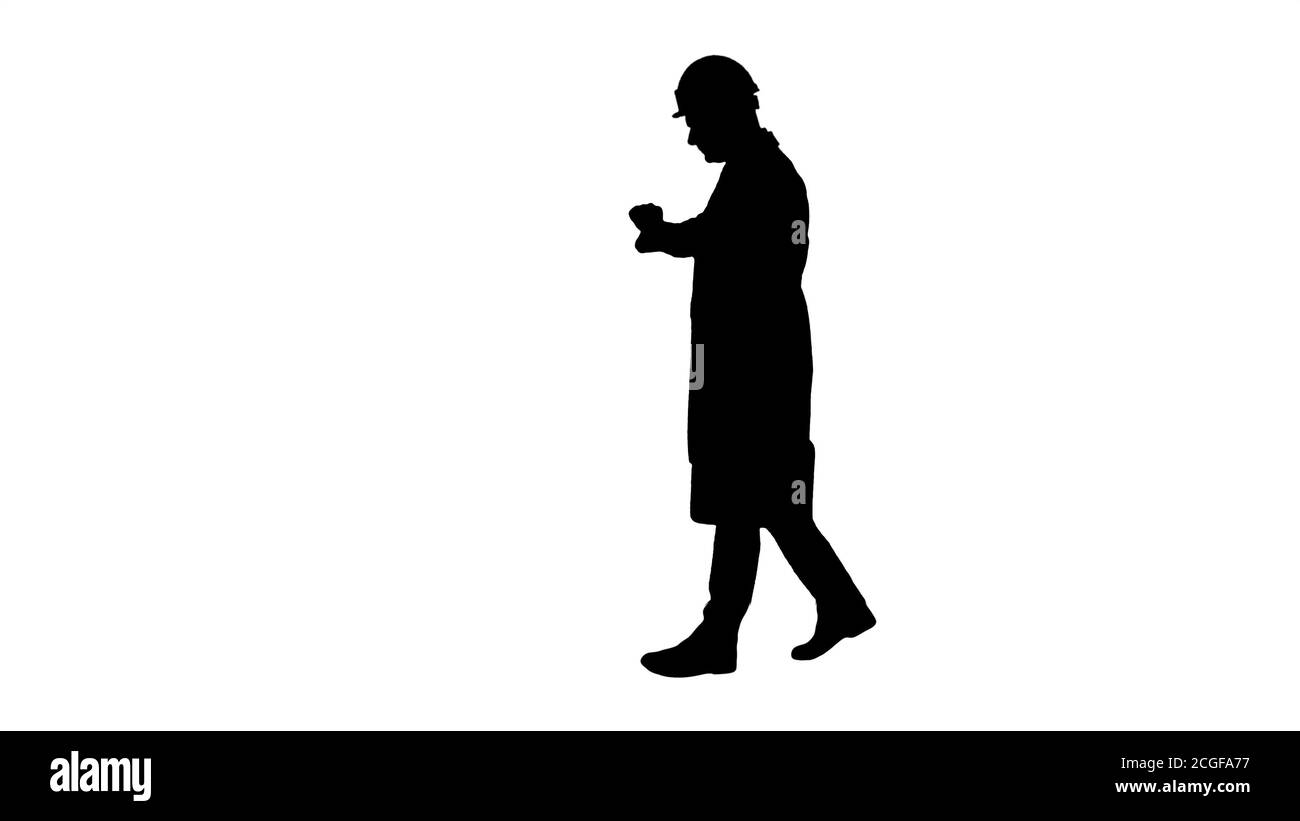 Silhouette Portrait of architect wearing hardhat looking at watch like being late. Stock Photo