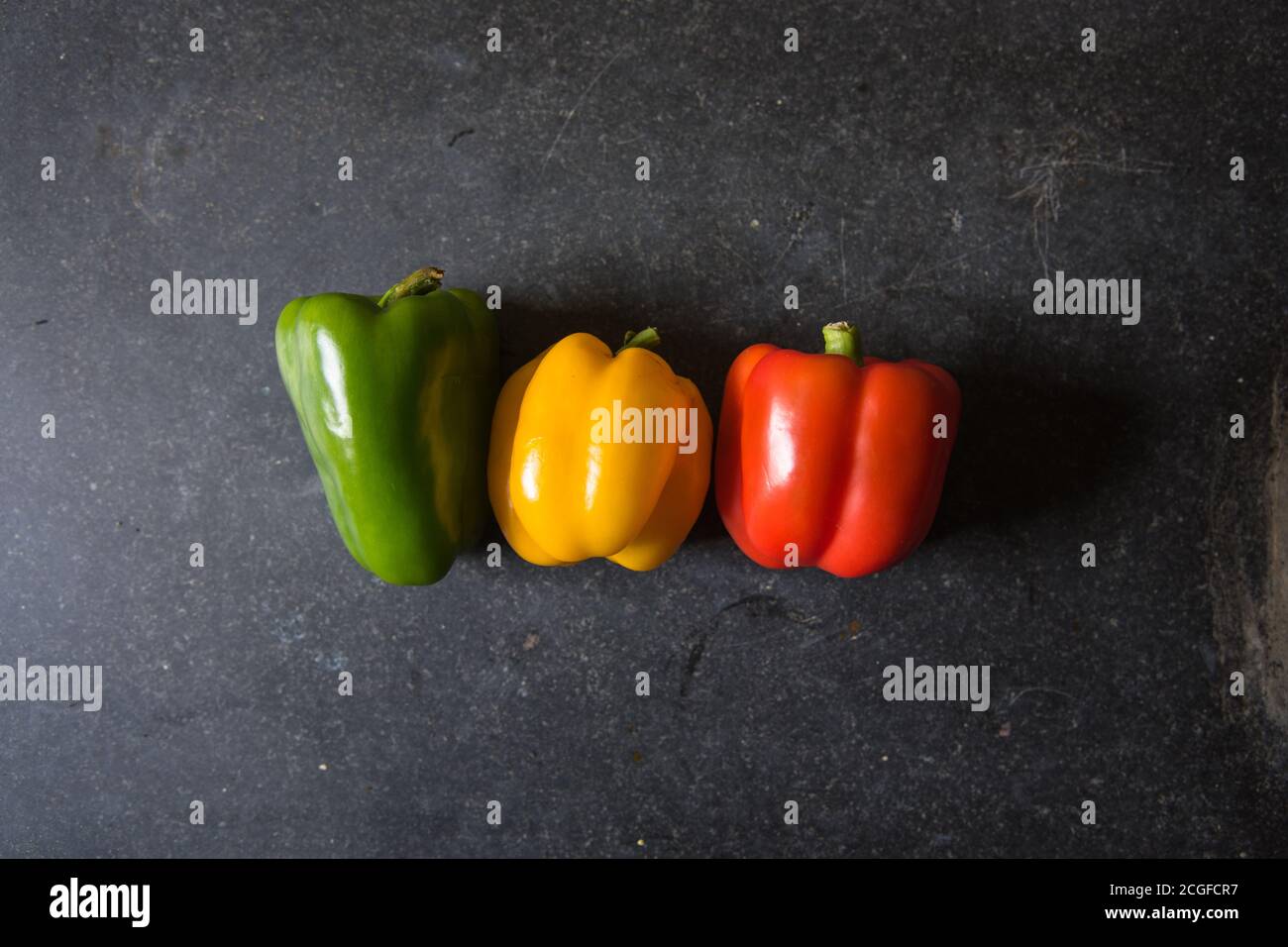 Top view of red yellow and green bell peppers on a black background Stock Photo