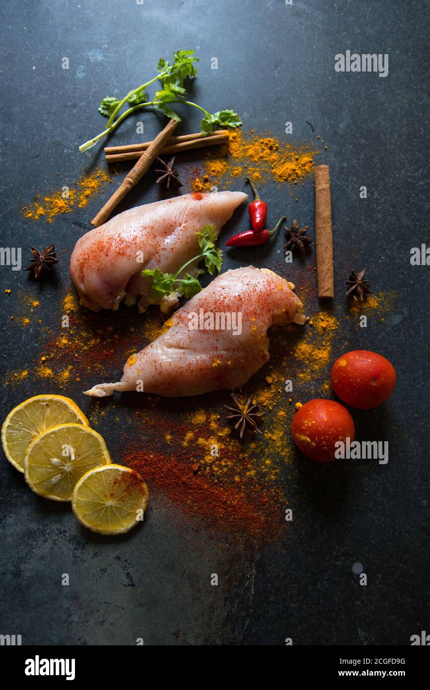 Vertical view of raw meat with vegetables and spices and condiments on a black background Stock Photo