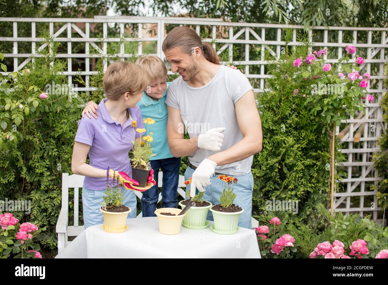 Parents Planting Planting flower. Gardening. Planting. Parents with son planting flower ...