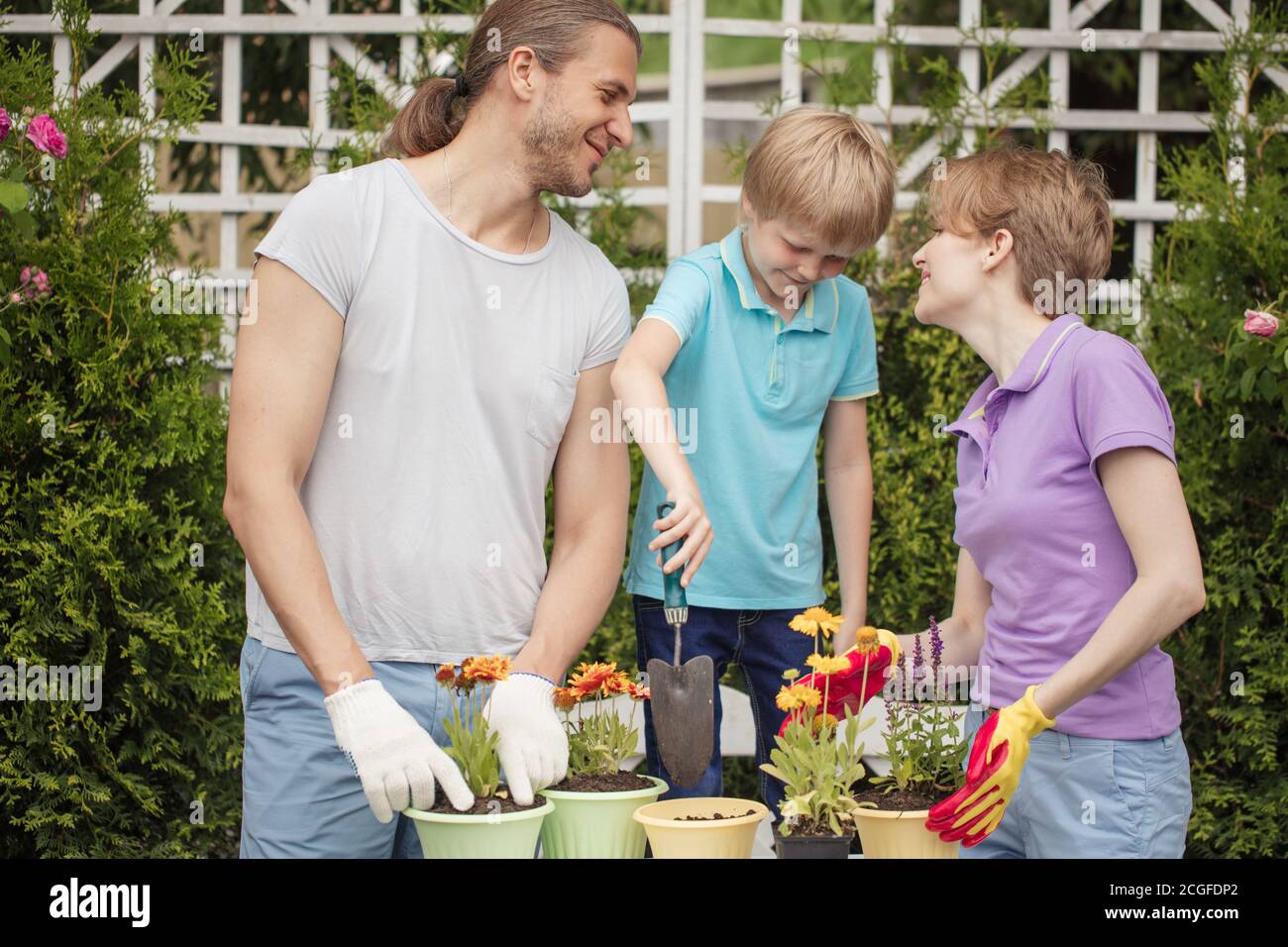 Parents Planting Boy kid helps parents planting flower in pot. Gardening, planting ...