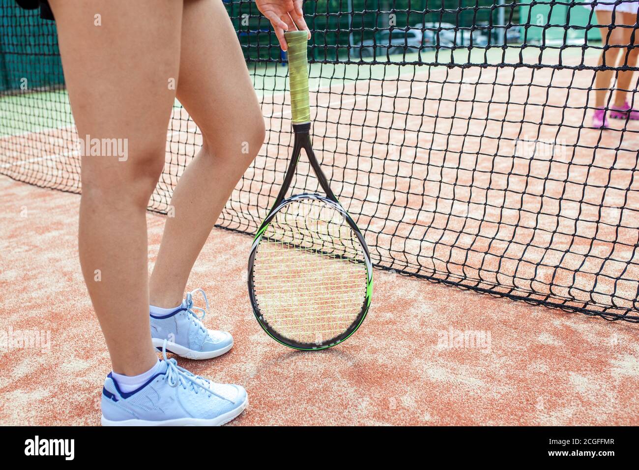 Portrait of female slim fit legs with tennis racket on court near the net.  close up outdoor shot. Sport People and Active Lifestyle Concept Stock  Photo - Alamy