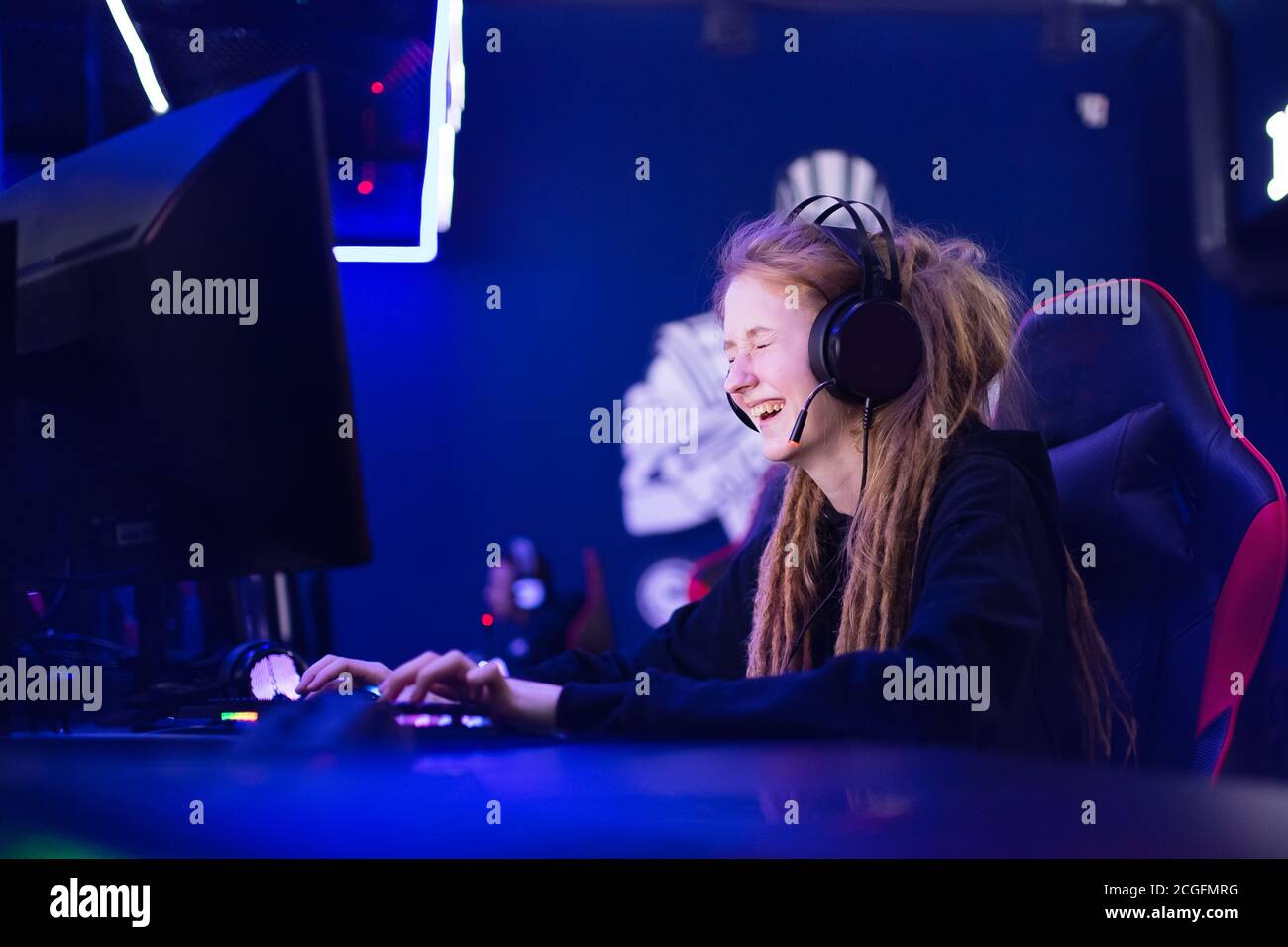 Streamer beautiful girl regrets losing professional gamer loser playing online games computer, neon color Stock Photo