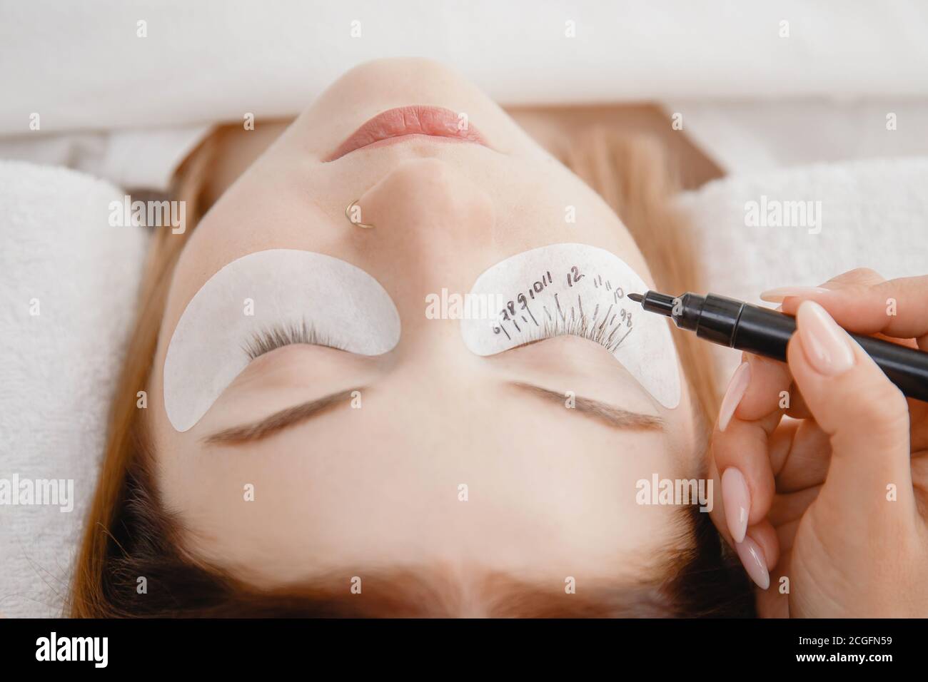Eyelash extension procedure. Master marker puts markup scheme guide
